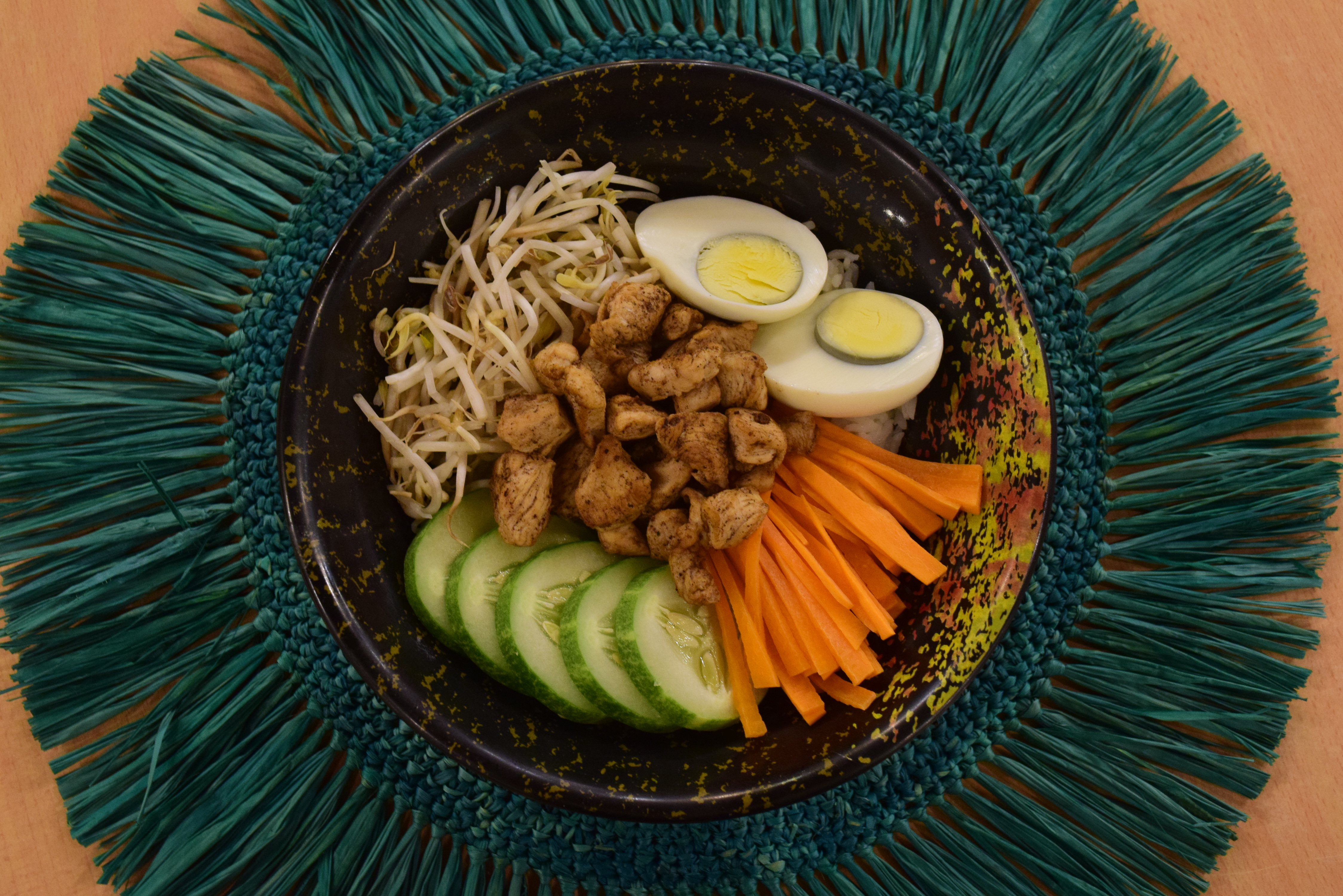 This salad-based poke bowl with chicken and eggs is mixed with cucumber, white onions, bean sprouts, and carrots. This can also be served with rice as base. 