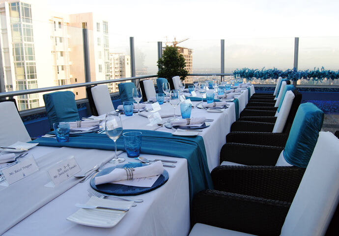 鮮やかなブルーとホワイトの色調が美しいテーブル席。窓からの眺めを楽しみながら、夜のディナーを楽しんで。